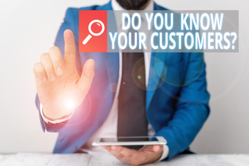 Writing note showing Do You Know Your Customers Question. Business concept for having a great background about clients Businessman with pointing finger in front of him