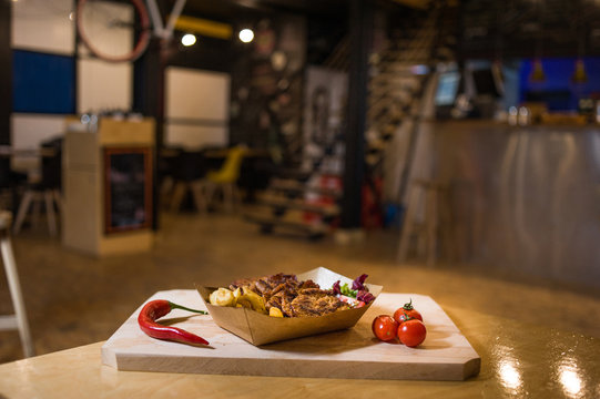 Appetizing fast food on a wooden board with fresh vegetables.