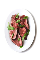plate with sliced medium rare roast beef 