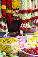 Colorful flower stall in an Indian street market, with garlands and baskets of flowers