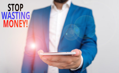 Word writing text Stop Wasting Money. Business photo showcasing advicing demonstrating or group to start saving and use it wisely Business concept with man holding mobile phone with touch screen