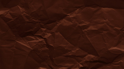 Crumpled sheet of dark brown paper texture. Creased background