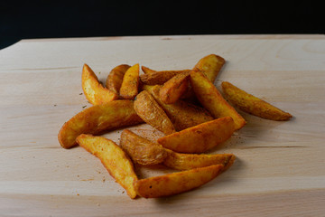 French fries on a wooden board isolated on black