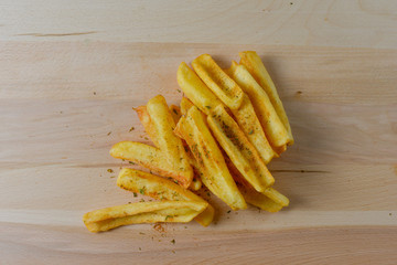 French fries on a wooden board isolated on black
