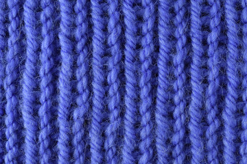 Fototapeta na wymiar Blue wool yarn knitted texture with large stitches. Hand knitted ribbing stitch pattern. Closeup