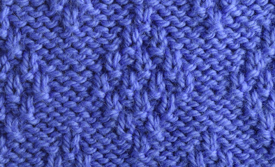 Blue wool yarn knitted texture with large stitches. Hand knitted 