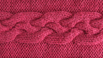 Pink wool yarn knitted texture. Hand knitted 12 stich braid cable pattern. Horizontal. Closeup