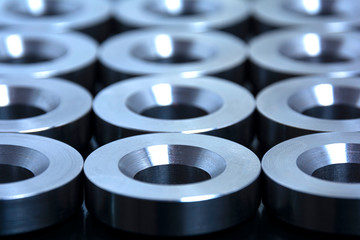 Abstract tech background for design and design. Metal parts machined on a lathe are laid out on a...