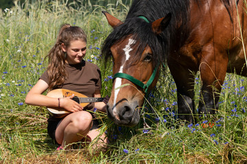 Mädchen  mit Pferd und Mandoline im Blumenfeld
