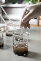 Scientist preparing soil extract at table, closeup. Laboratory analysis