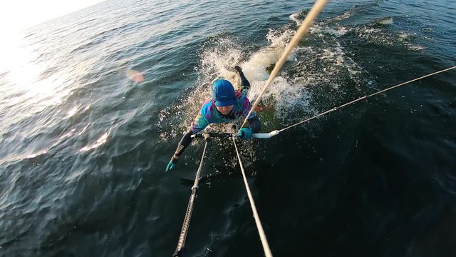 Top view of a male kitesurfer falling from the board
