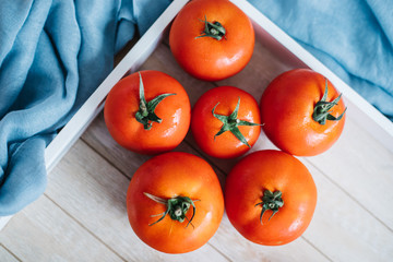 Fresh ripe tomatoes in wooden crate.