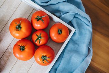 Fresh ripe tomatoes in wooden crate.
