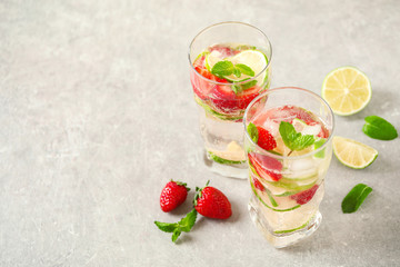 Tasty refreshing drink  with strawberry on light grey table. Space for text