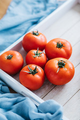 Fresh ripe tomatoes in wooden crate.