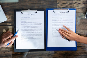 Obraz premium Two Businesspeople Working On Contract Paper