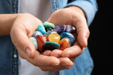 Young woman holding many beautiful gemstones, closeup
