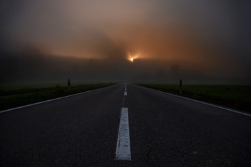 road towards horizon during sunrise with fog