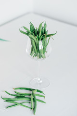 fresh green beans in glass. green beans isolated on a white backgroundbackground hand holding green kidney bean in glass. carrot with a crat