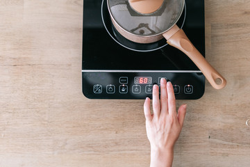 Woman cooking food at small electric stove