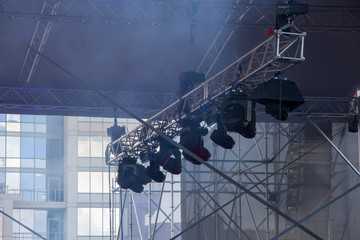 A light ramp suspended above the stage with floodlights and lighting fixtures, concert venues and...