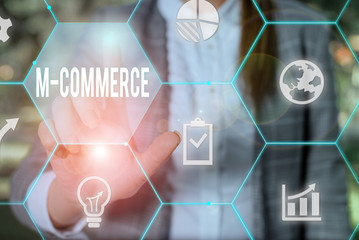 Text sign showing M Commerce. Business photo text commercial transactions conducted electronically by mobile phone Female human wear formal work suit presenting presentation use smart device