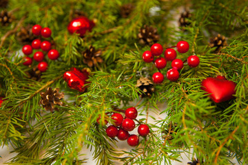 Christmas or New Year background: fir tree branches, red glass balls, decoration and cones on a white background