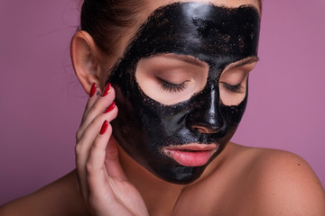 Beautiful young european woman apply clay mask on her face. beauty spa concept
