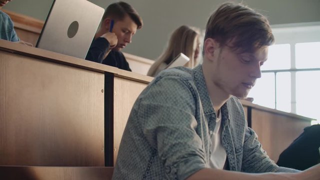 The Camera Moves Through The Audience Where The Students Write A Lecture On Laptops And Notebooks For Professors In A Large Classroom Of A University Or College