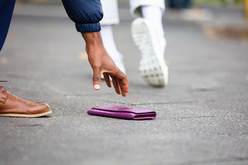 Person Picking Up Lost Purse