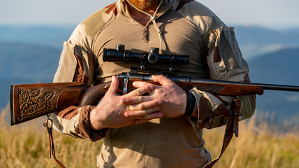 Hunter man. Hunter with Powerful Rifle with Scope Spotting Animals. Illegal Hunting Poacher in the...
