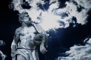 Ancient statuue of Hercules on the sky background.
