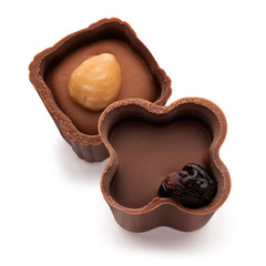 Two small chocolate basket with cream, nut and prunes on a white background