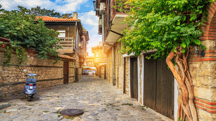 Fototapeta na wymiar City landscape - view of the old streets and homes in balkan style, the Old Town of Nesebar, in Burgas Province on the Black Sea coast of Bulgaria