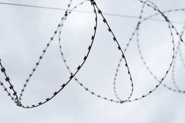 Barbed wire fence against the sky. Caution, danger zone.