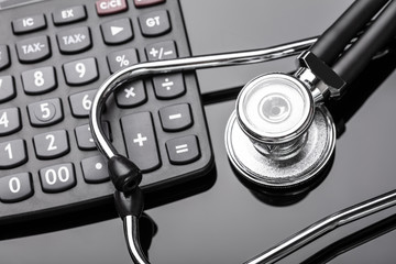 Calculator And Stethoscope On Black Background