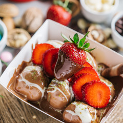 turkish lokma turkish bite dessert with chocolate and white chocolate sauce. strawberry and banana new generation bite