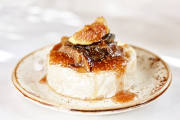 Baked Camembert cheese with fig jam and fresh figs, hard sunlight, deep shadow. sunny weather. fashion light, copy space