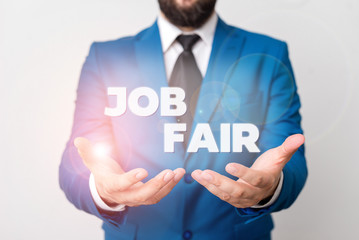 Text sign showing Job Fair. Business photo showcasing An event where a demonstrating can apply for a job in multiple companies Man with opened hands in fron of the table. Mobile phone and notes on the