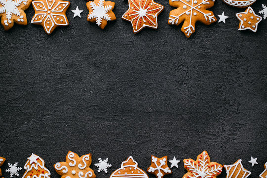 Christmas background with homemade gingerbread cookies on black table, copy space. Festive food, New Year celebration traditions