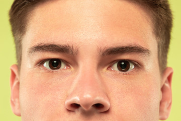 Obraz premium Caucasian young man's close up shot on studio background. Beautiful male model with well-kept skin. Concept of human emotions, facial expression, sales, ad. Copyspace. Brown eyes looking at camera.