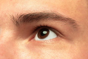 Caucasian young man's close up shot on studio background. Beautiful male model with well-kept skin. Concept of human emotions, facial expression, sales, ad. Copyspace. Brown eye looking at side.