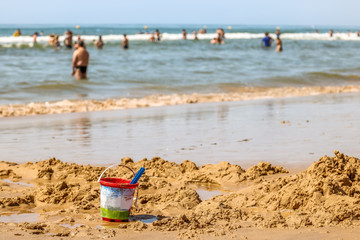 Fototapeta na wymiar Plastic toys on beach sand in summer day. Kid play on beach, vacation concept.