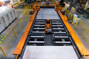 Roller conveyor with moving steel sheet in factory workshop