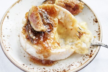 Baked Camembert cheese with fig jam and fresh figs, copy space