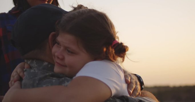 Wheelchaired soldier hugging his daughter