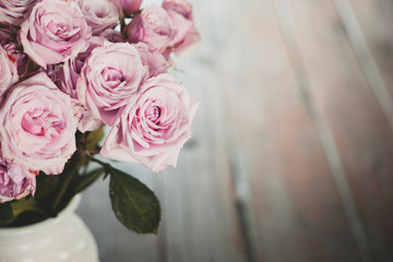 Soft Pink dozen roses in white vase on a farmhouse table with a soft, airy and hazy look
