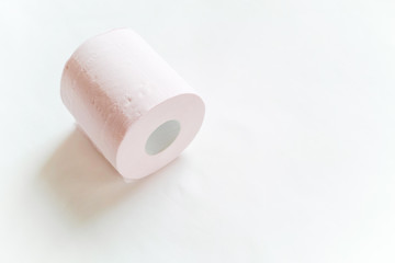 白バックの左寄りに1ロール転がるように置いてあるピンクの新品のトイレットペーパー