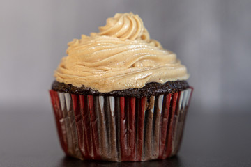One single chocolate gourmet cupcake with peanut butter frosting. Dessert with lots of calories.