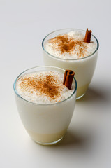 Eggnog with cinnamon and nutmeg for christmas and winter holidays. Eggnog isolated on white background.